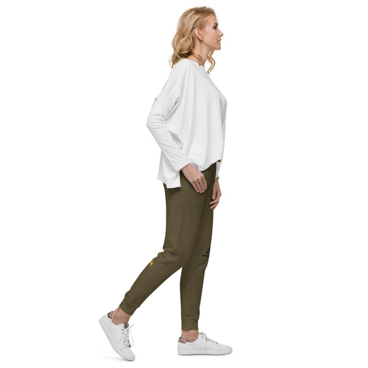 Woman wearing a white oversized sweater and military green jogger pants on a white background