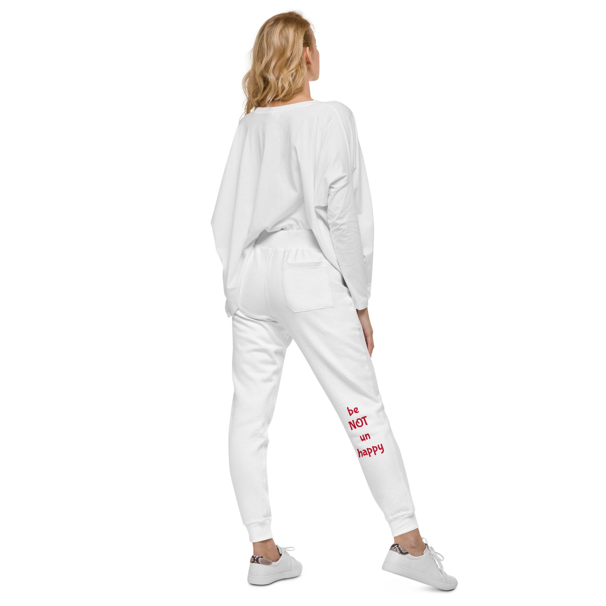 Woman wearing a white tracksuit with text on the pants against a white background