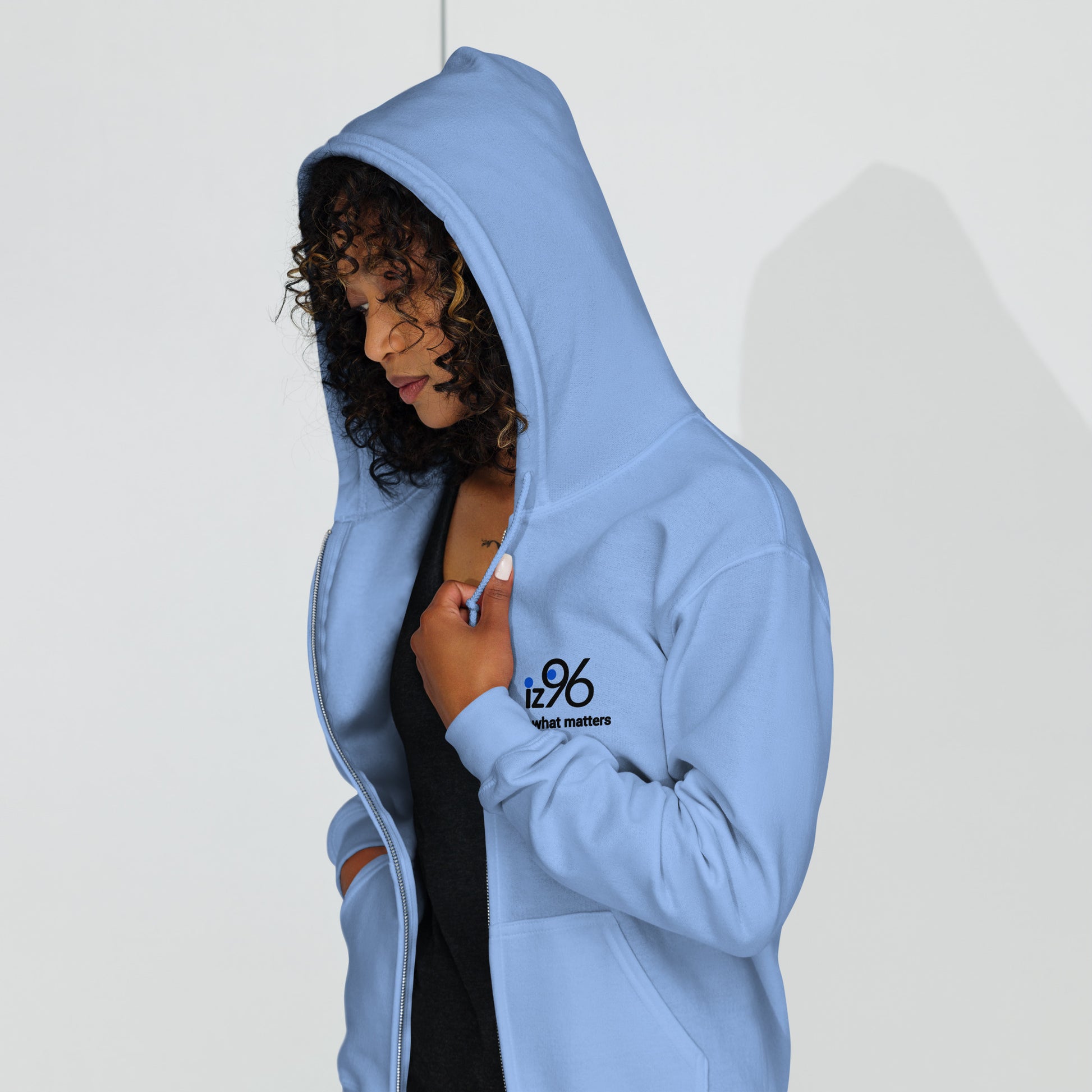 Person wearing a light blue hoodie with a brand logo on a white background