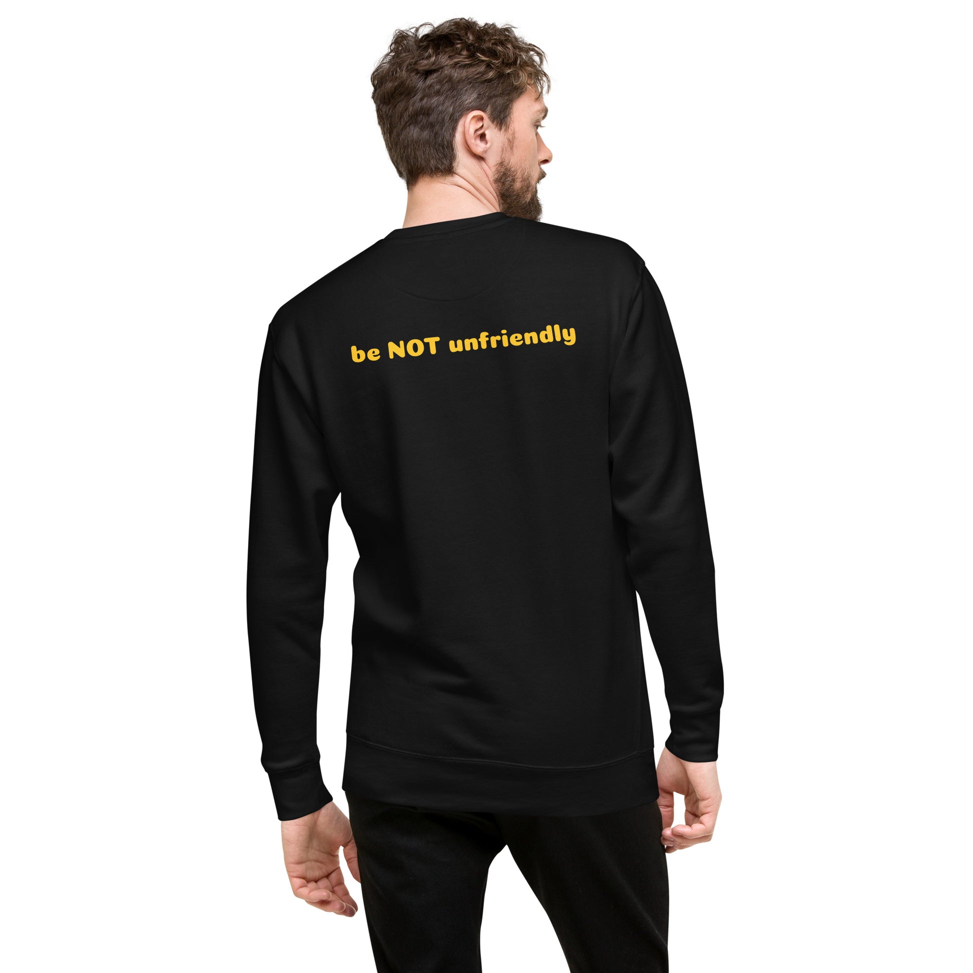 Man wearing a black sweatshirt with yellow text on the back, standing against a white background