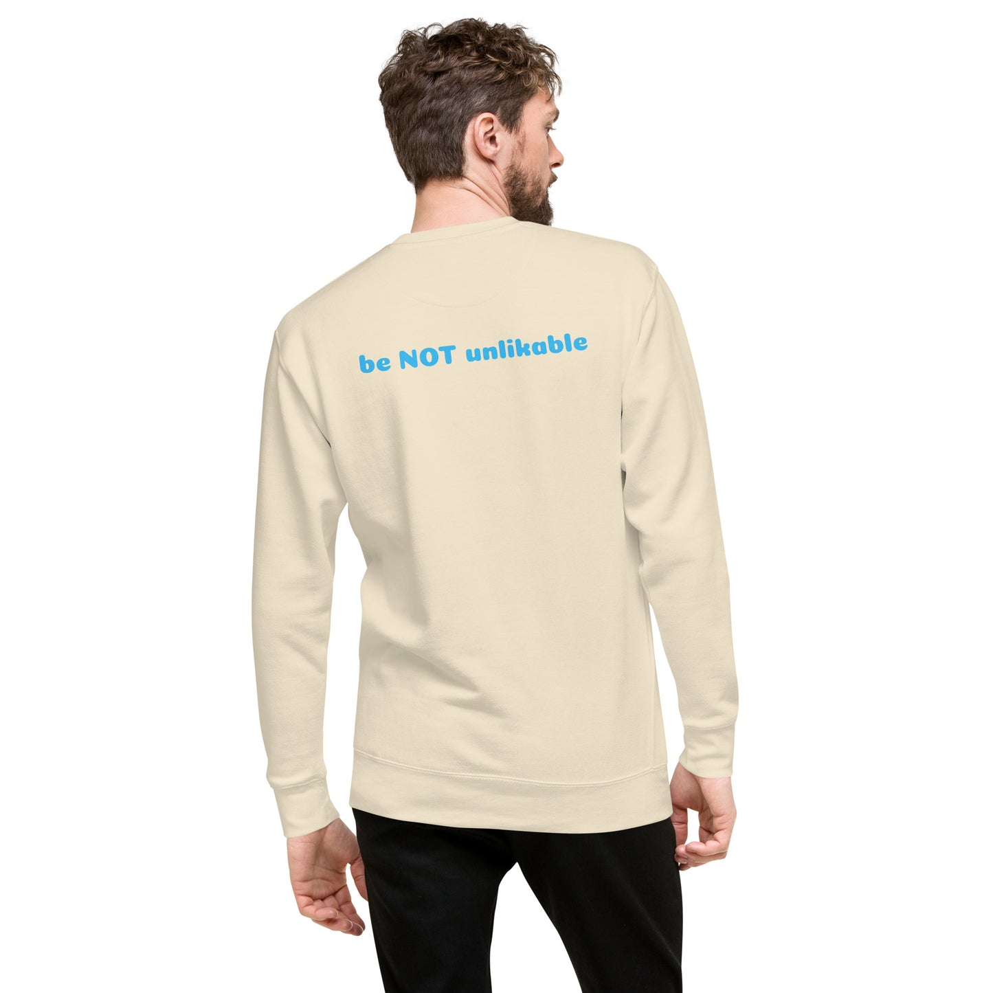 Man wearing a beige long-sleeve shirt with 'be NOT unlikable' text on the back, on a white background