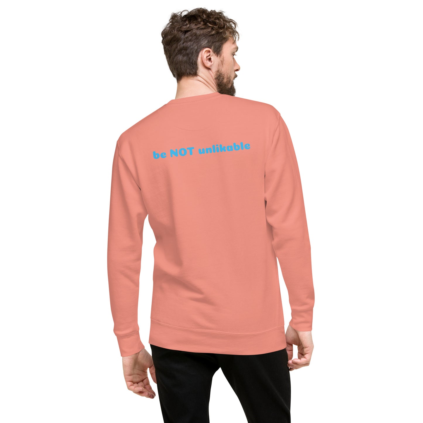 Man wearing a peach long-sleeve shirt with text on the back against a white background