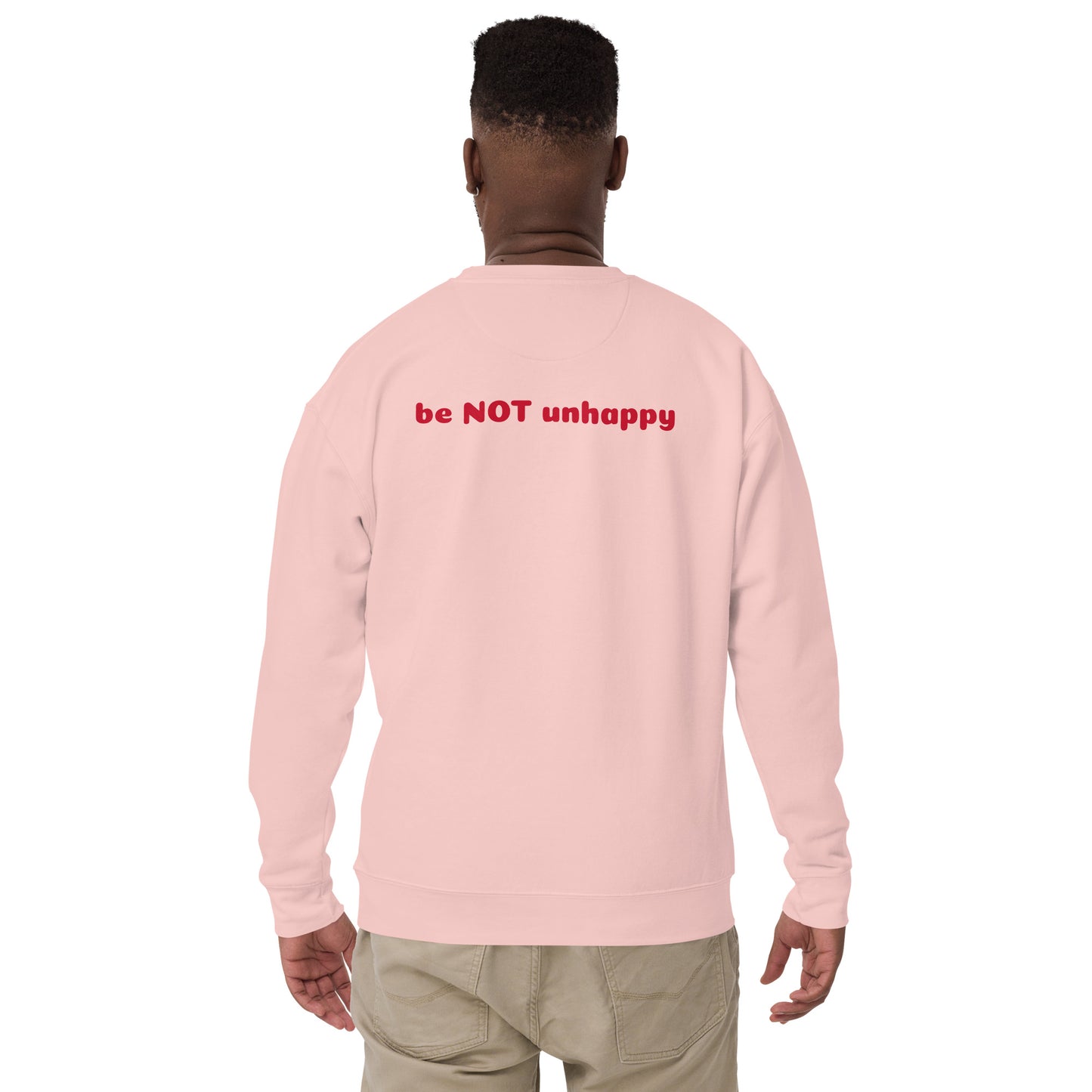Person wearing light pink sweatshirt with 'be NOT unhappy' text on the back, standing against a white background.