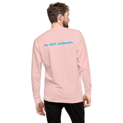Person wearing a light pink long-sleeve shirt with 'be NOT unlikable' text on the back.