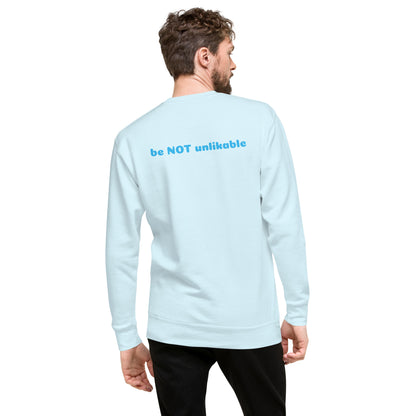 Man wearing a sky blue long-sleeve shirt with text on the back, standing against a white background