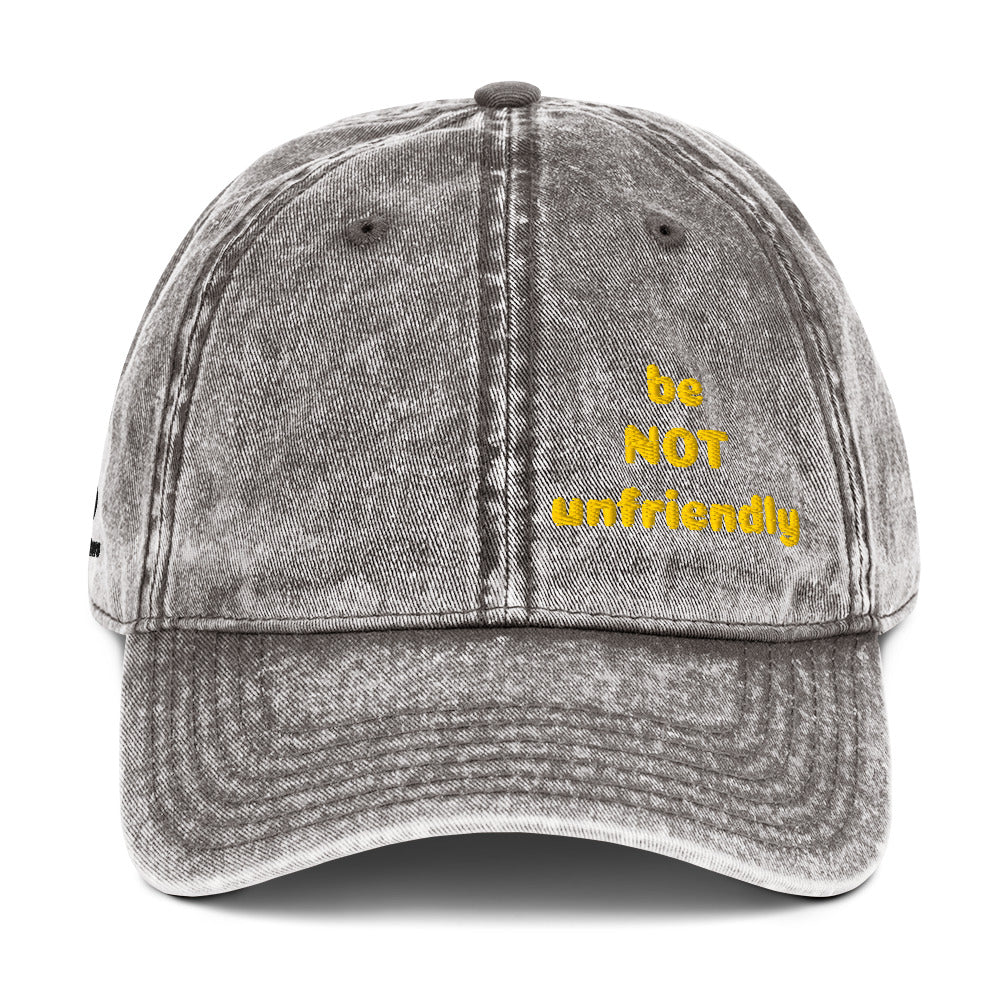 Gray denim cap with 'be NOT unfriendly' text in yellow on a white background