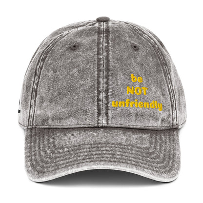 Gray denim cap with 'be NOT unfriendly' text in yellow on a white background