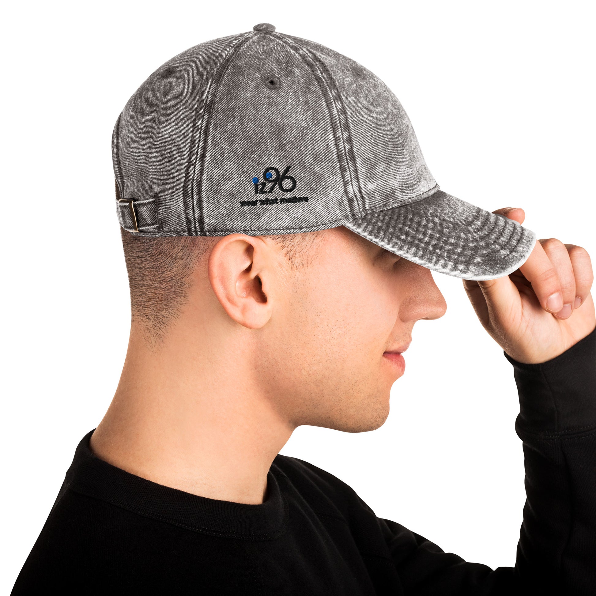 Person wearing a gray denim cap with a logo on a white background