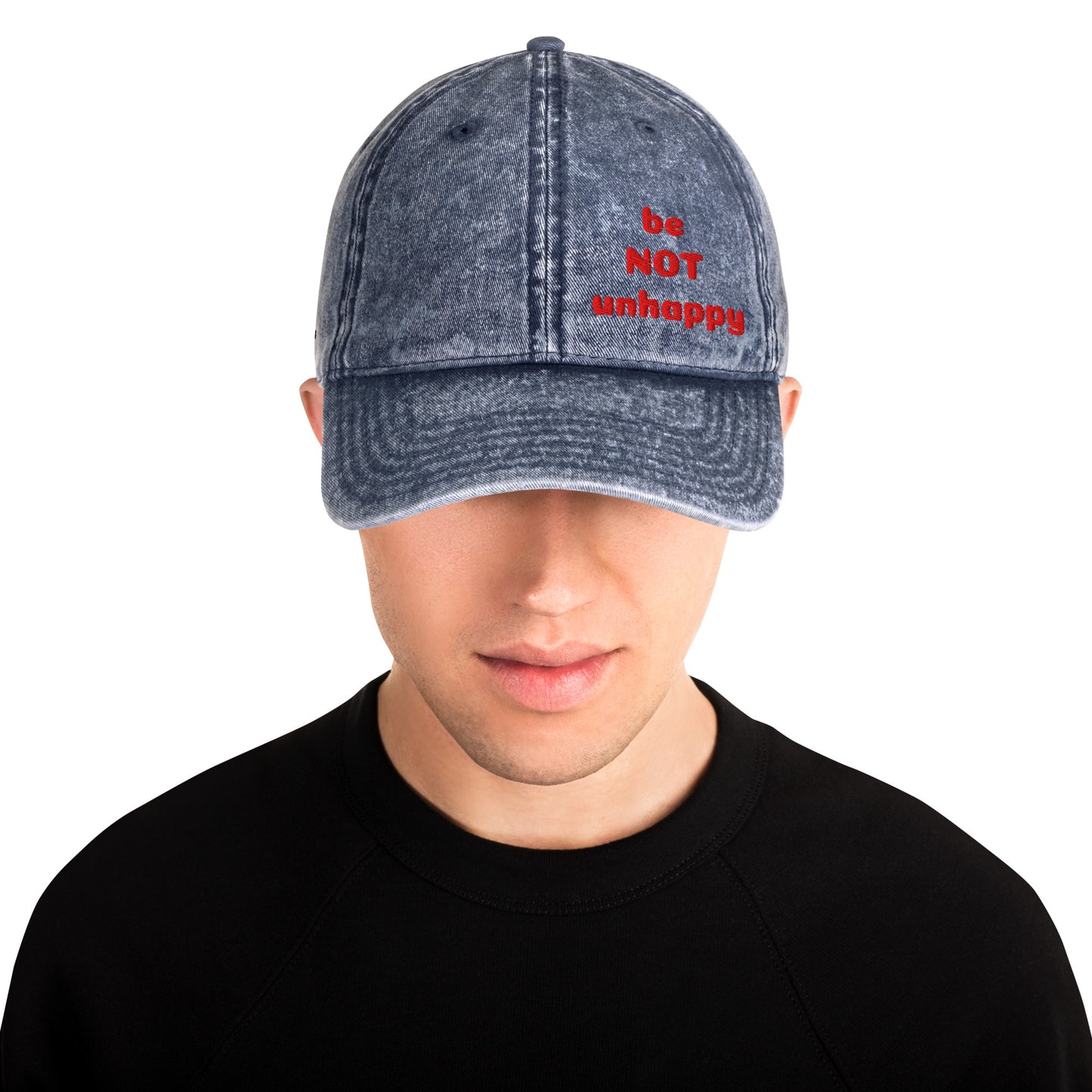 Person wearing a denim cap with 'be NOT unhappy' text on a white background