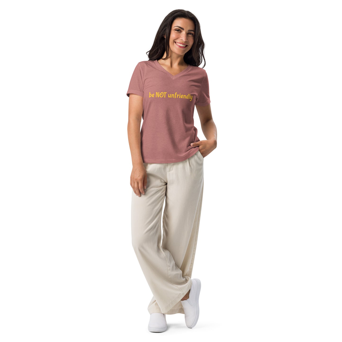 Woman wearing a pink t-shirt with text and beige pants on a white background