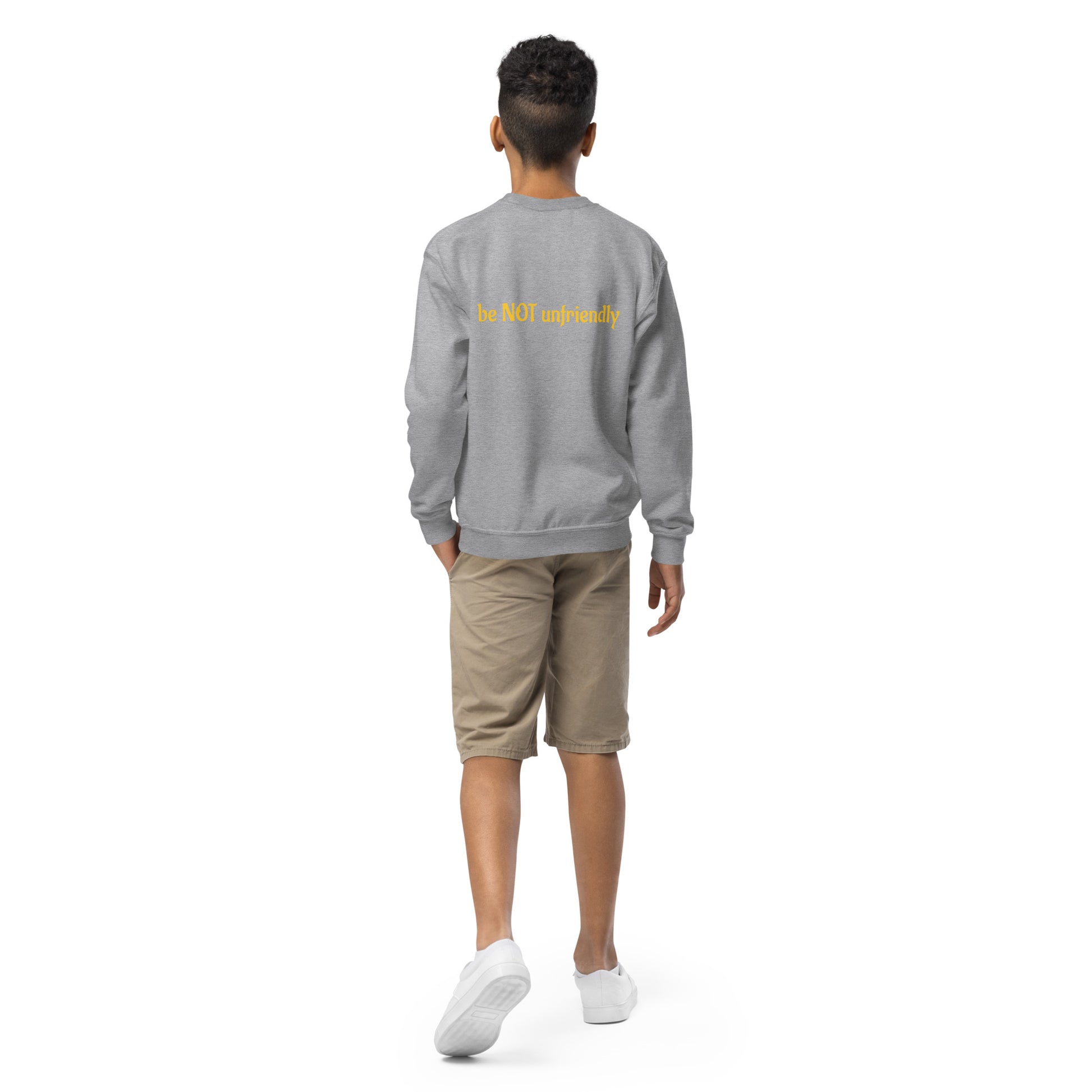 Person wearing a gray sweatshirt with yellow text on the back, standing against a white background