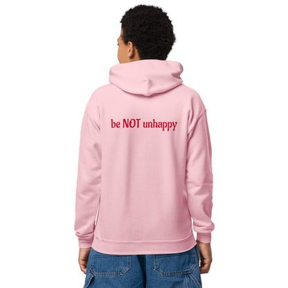 Person wearing a pink hoodie with 'be NOT unhappy' text on the back, standing against a white background.