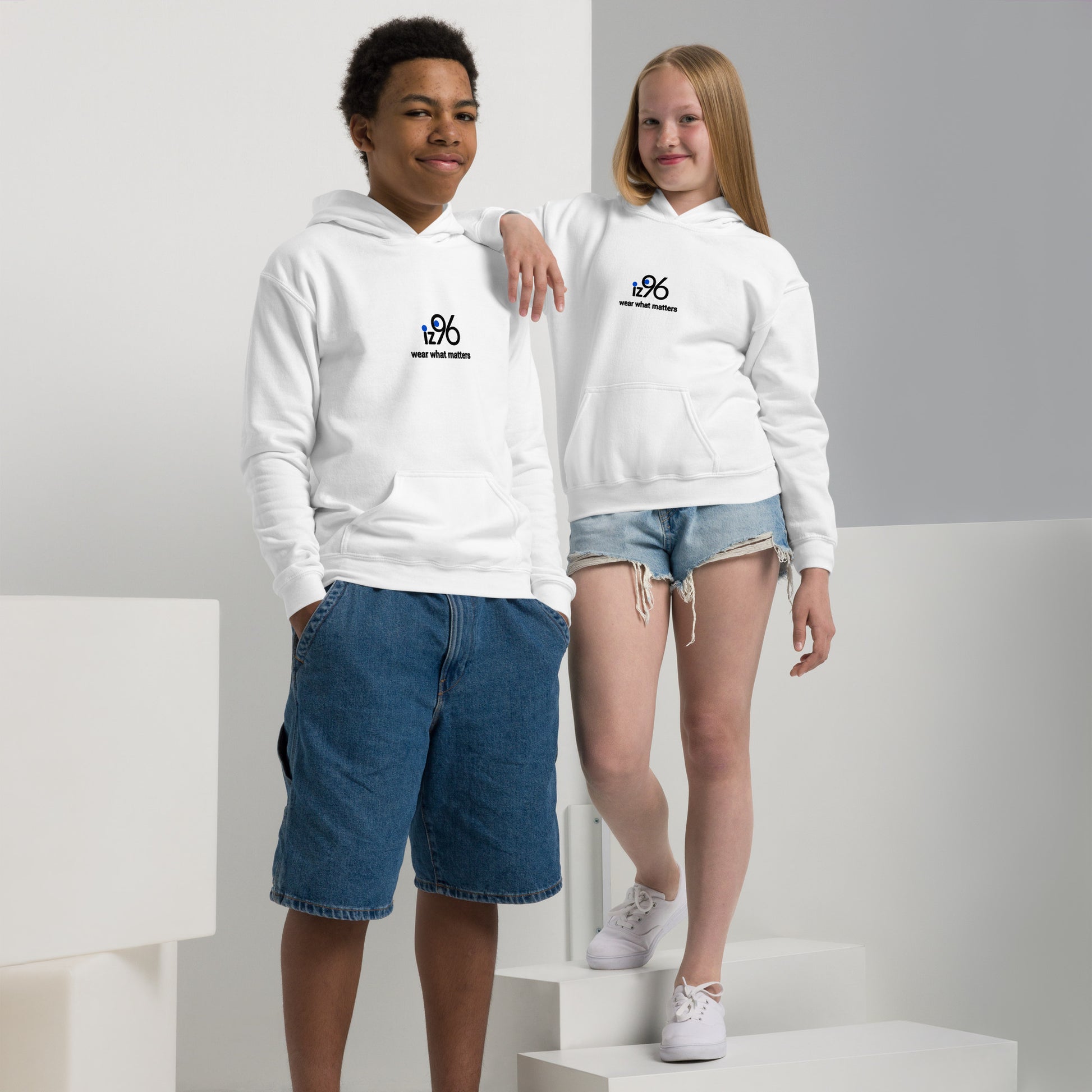 Two children wearing white hoodies with 'iz96 wear what matters' logo design on a white background