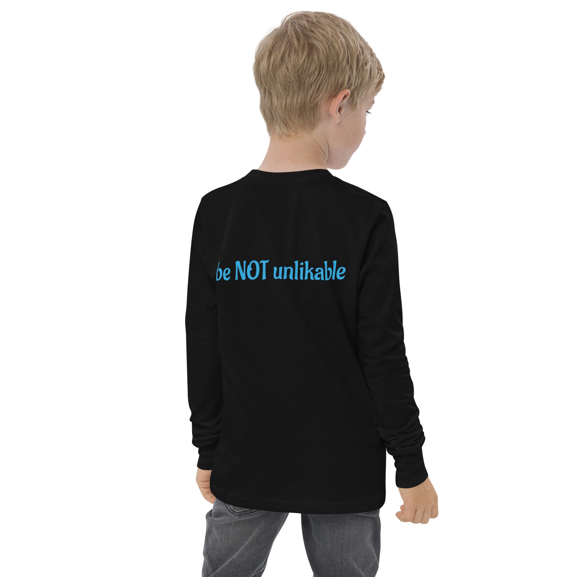Child wearing a black long-sleeve shirt with 'be NOT unlikable' text on the back, standing against a white background.