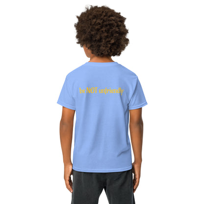 Boy wearing a light blue t-shirt with a logo on the back, standing against a white background